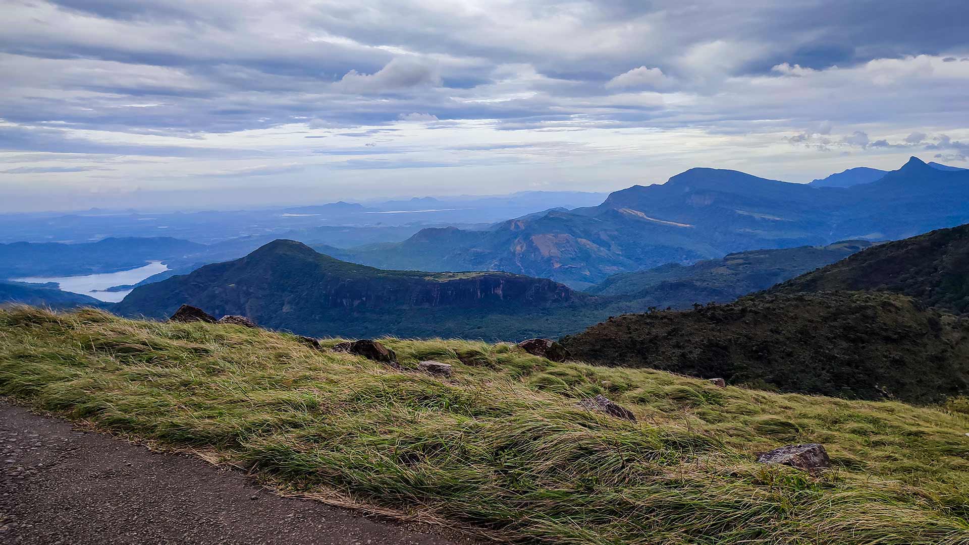 Panoramic view from Riverston Top showing Knuckles mountain ranges, valleys and distant reservoir on a cloudy day